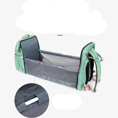 Green and gray baby travel crib with mesh side on a white background