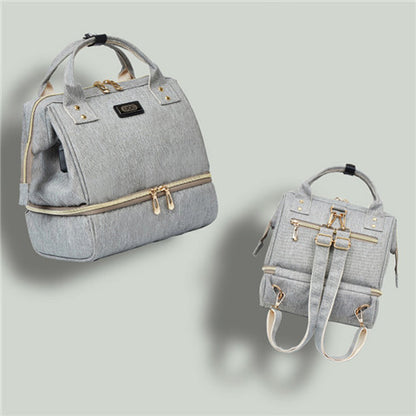 Gray backpack with gold zippers on a light gray background