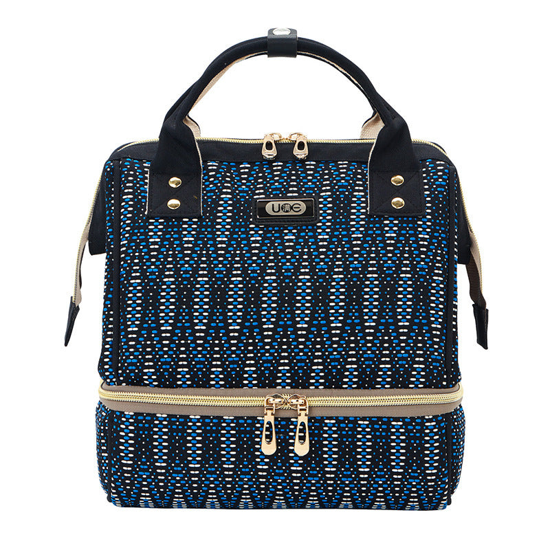 Blue and black patterned handbag with gold accents on a white background
