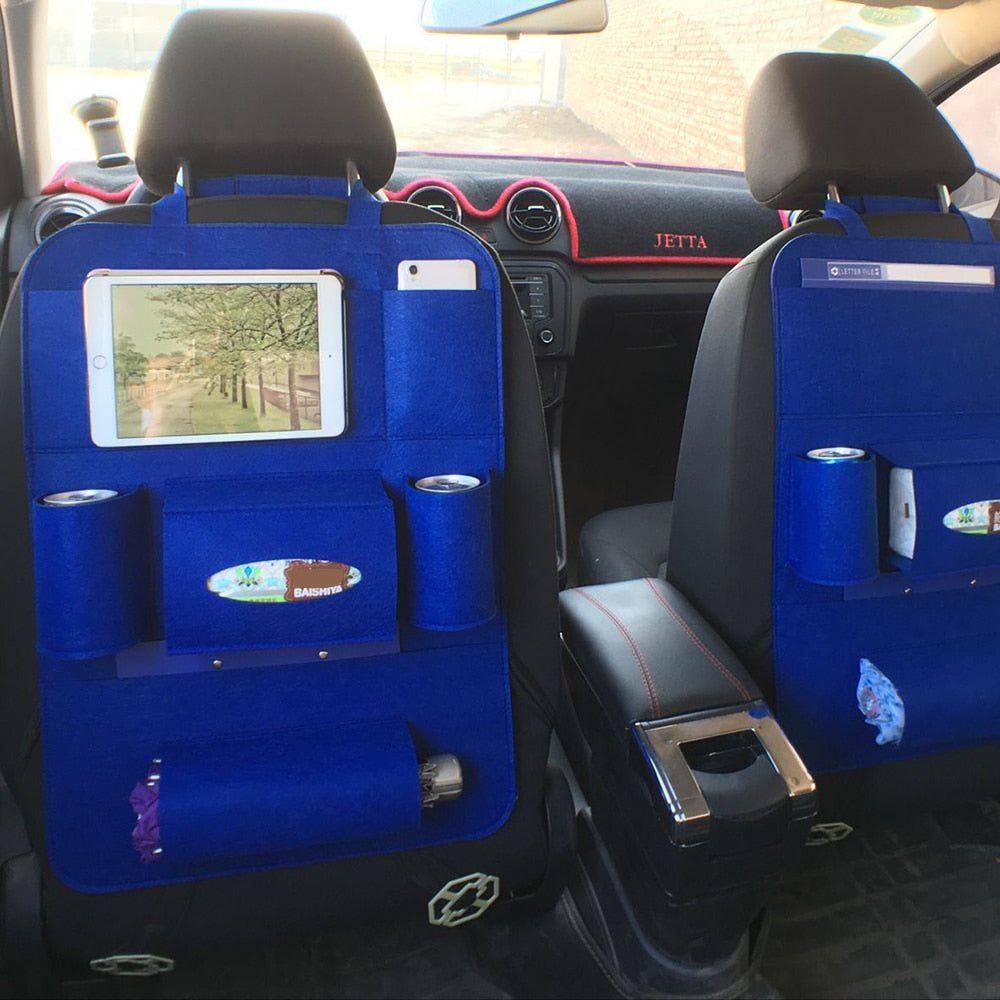 Car interior with blue back seat covers featuring pockets and cup holders.