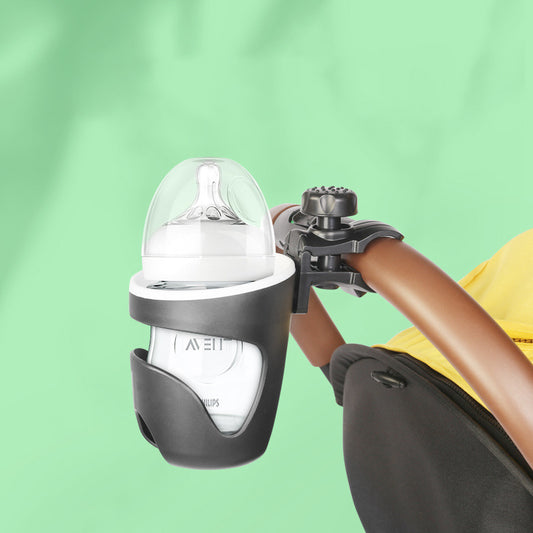 Baby bottle holder attached to a stroller armrest with a green background